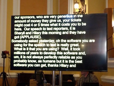 A large screen with a black background and yellow text.